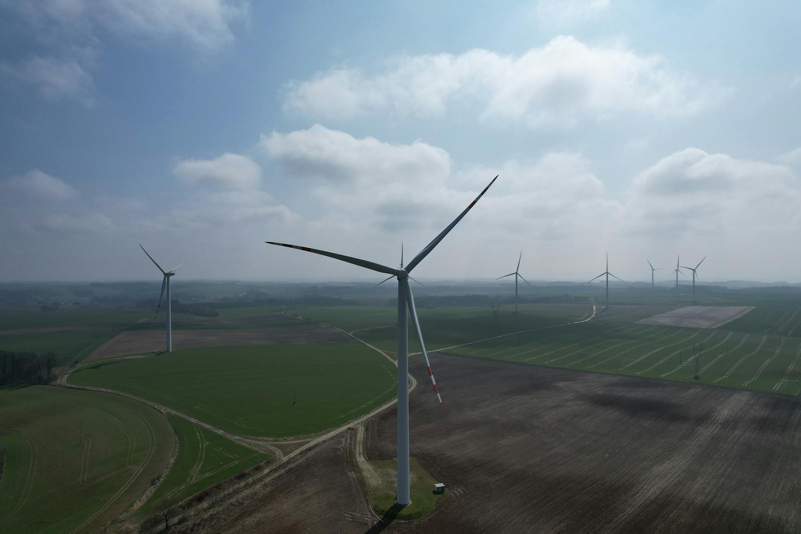 Turbiny wiatrowe pośród pól jako przykład inwestycji OZE